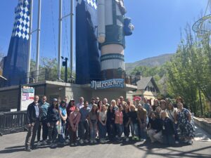 Davis Chamber Leadership Institute graduating class lined up in front of Lagoon's new Nutcracker ride on final day, last group photo of the cohort celebrating together.