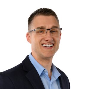 Leadership trainer Mark Erickson celebrating one year as a full‑time entrepreneur in a professional suit.